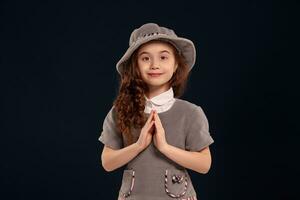 Studio shot of a lovely little kid with a long, curly hair posing on a black background. photo