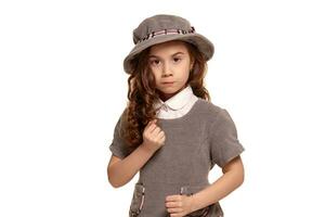 Studio shot of a lovely little kid with a long, curly hair posing isolated on white background. photo