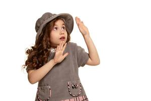 Studio shot of a lovely little kid with a long, curly hair posing isolated on white background. photo