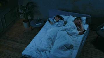 insatisfeito casado casal usar Smartphone às noite enquanto dormindo. video