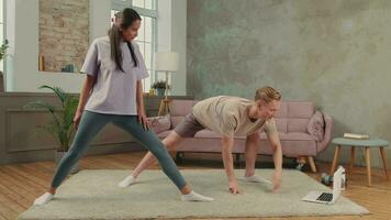 The family is engaged in fitness yoga at home using online technology. video