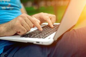 Close-up shot of handsome man's hands touching laptop computer's screen. photo