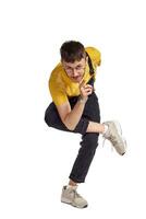 Full-length portrait of a funny guy dancing in studio isolated on white background. photo