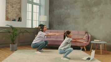 The family is engaged in fitness yoga at home using online technology. video