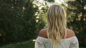 Portrait of a caucasian woman in nature near green trees. video