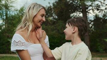 Mom hugs with her son on the lawn. video