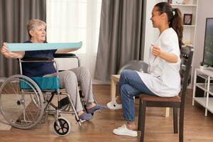 médico haciendo rehabilitación con mayor mujer en silla de ruedas. capacitación, deporte, recuperación y levantamiento, antiguo persona Jubilación hogar, cuidado de la salud enfermería, salud apoyo, social asistencia, médico y hogar Servicio foto