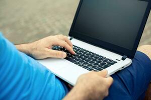 Close-up shot of handsome man's hands touching laptop computer's screen. photo