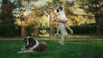 A loving father plays with his sons on the lawn near the house. video