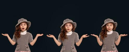 Portrait of a beautiful little girl in a gray dress and hat posing on a black background. photo