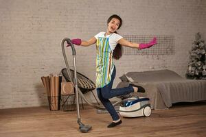 Happy woman cleaning home,dancing with vacuum cleaner and having fun, copy space. photo