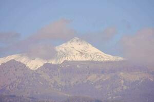 a snowy mountain with a blue sky and clouds photo