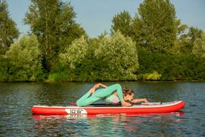 Woman practicing yoga on the paddle board in the morning photo