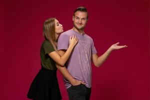 joven bonito Pareja posando en el estudio, Rápido emociones y gestos, sonriente, en un borgoña antecedentes foto