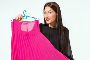 Happy woman shopping and choosing clothes isolated on a white background photo