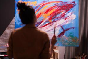 Painter in art workshop looking at painting composition in art studio. Modern artwork paint on canvas, creative, contemporary and successful fine art artist drawing masterpiece photo