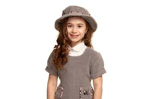 Studio shot of a lovely little kid with a long, curly hair posing isolated on white background. photo