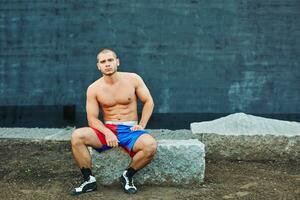 The sportsman has a rest, sitting on rock photo