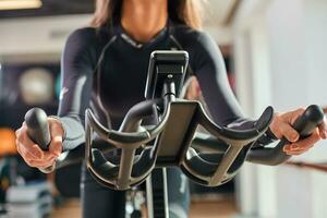 Woman hands on a bar stationary bike the gym photo