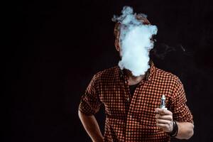 young man smoking electronic cigarette photo