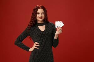 Beautiful redheaded woman is holding some playing cards. Casino photo