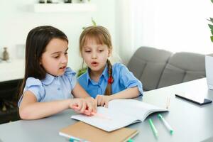 aprendizaje desde hogar, hogar colegio niño concepto. pequeño niños estudiar en línea aprendizaje desde hogar con ordenador portátil. cuarentena y social distanciamiento concepto. foto