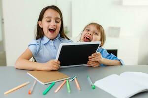 Pretty stylish schoolgirls studying during her online lesson at home, social distance during quarantine, self-isolation, online education concept photo