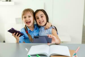 dos pequeño muchachas estudiando en línea. distancia aprendizaje en línea, aprendizaje electrónico, concepto foto