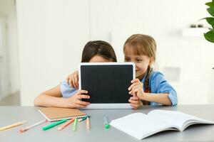 Pretty stylish schoolgirls studying during her online lesson at home, social distance during quarantine, self-isolation, online education concept photo