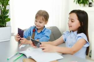 dos pequeño muchachas estudiando en línea. distancia aprendizaje en línea, aprendizaje electrónico, concepto foto