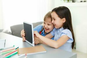 Pretty stylish schoolgirls studying during her online lesson at home, social distance during quarantine, self-isolation, online education concept photo