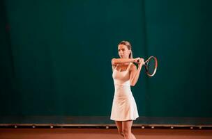 Indoor tennis court playing athlete. photo