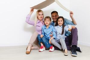 contento familia jugando dentro nuevo hogar. padre, madre y niño teniendo divertido juntos. Moviente casa día y real inmuebles concepto foto