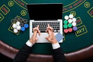 casino, online gambling, technology and people concept - close up of poker player with playing cards photo