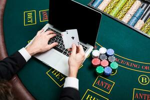 casino, online gambling, technology and people concept - close up of poker player with playing cards photo