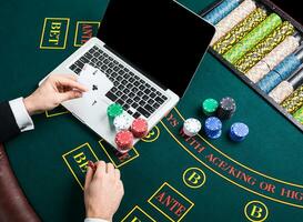 casino, online gambling, technology and people concept - close up of poker player with playing cards photo