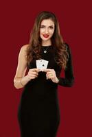 Beautiful caucasian woman in black dress with poker cards gambling in casino photo