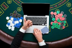 casino, online gambling, technology and people concept - close up of poker player with playing cards photo