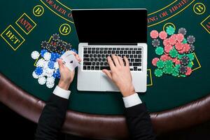 casino, online gambling, technology and people concept - close up of poker player with playing cards photo