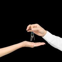 A man hands the keys to a girl isolated on white studio background photo