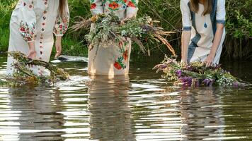 adivinación en coronas y agua, el ivan Kupala día festivo, muchachas lanzar coronas en el agua. foto