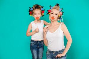 Funny family on a background of bright blue wall. Mother and her daughter girl with a paper accessories. photo