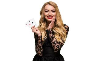 hermosa joven mujer participación dos as de tarjetas en su mano aislado en negro antecedentes foto