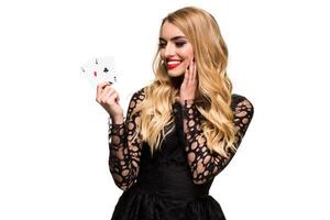 Beautiful young woman holding two ace of cards in her hand isolated on black background photo