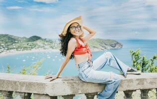 Happy tourist woman in hat on a viewpoint. Smiling vacationer girl in a viewpoint. Travel and tourism promotion concept photo