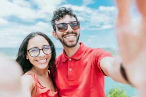 Happy Young couple on vacation taking a selfie near the beach. Smiling young couple taking a self portrait in the bay of San Juan del Sur photo