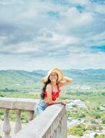 contento turista mujer en sombrero en un punto de vista. retrato de veraneante niña en un punto de vista. viaje y turismo promoción concepto foto