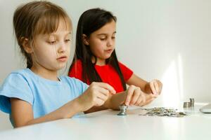 retrato de pequeño muchachas sentado a mesa y calculador dinero foto