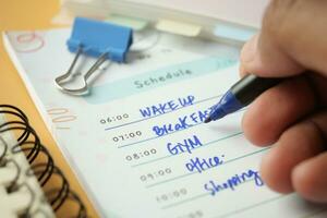 writing on a daily planner on table. photo