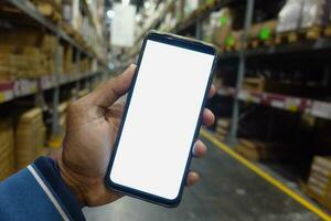 business owner holding phone mock up in warehouse. photo